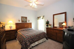 A bedroom with a bed, dresser, mirror, lamp, and ceiling fan. - Huge Home in Quiet Crescent Lakes - CL001 (Kissimmee)