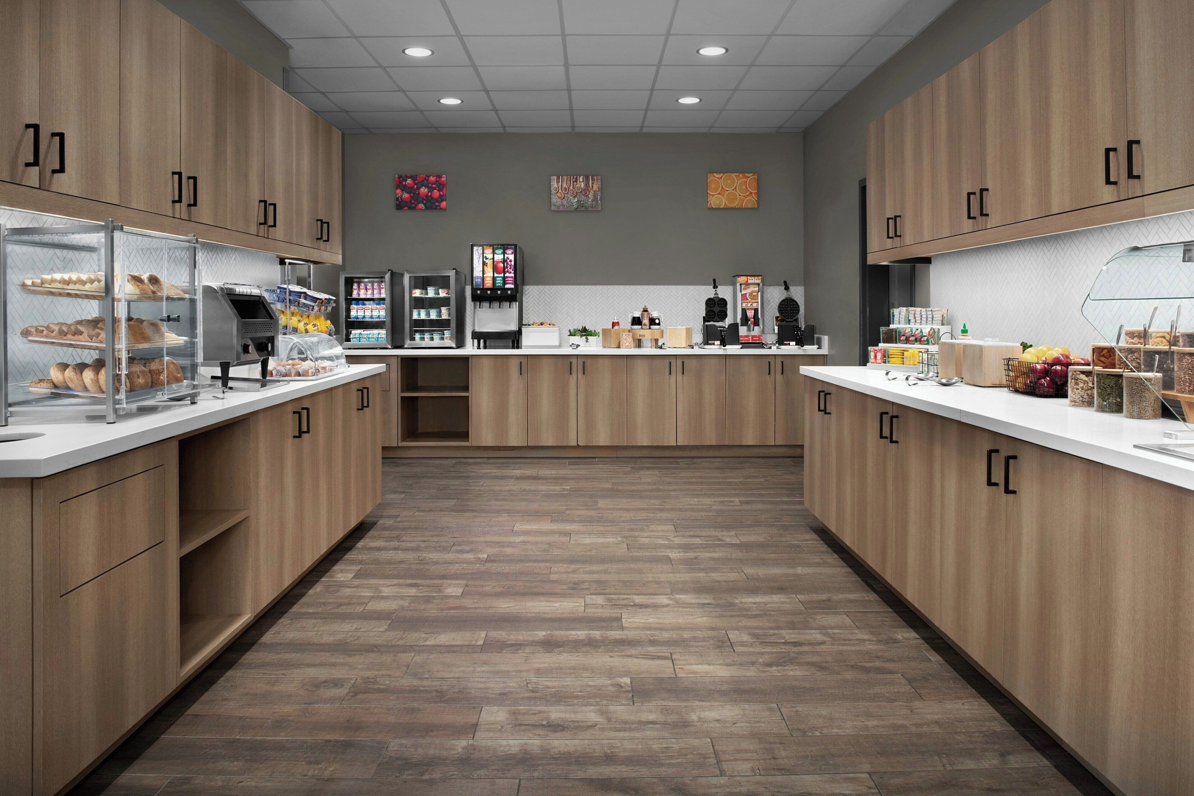 Une cuisine moderne avec des meubles en bois, un îlot central et divers appareils électroménagers.