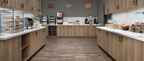 A modern kitchen with wooden cabinets, a central island, and various appliances.