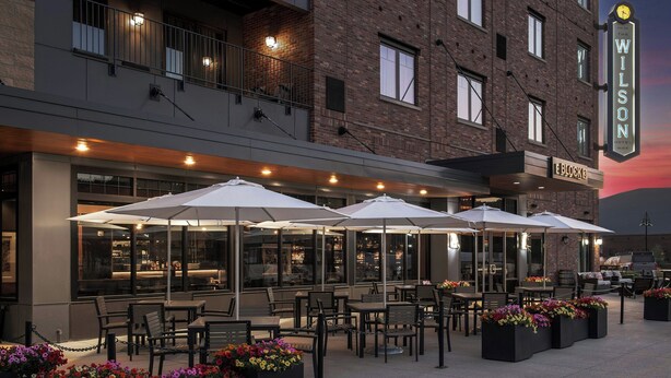 An outdoor seating area with tables and umbrellas at The Wilson Hotel.