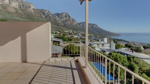 Un balcon offrant une vue sur un paysage montagneux et un plan d’eau.