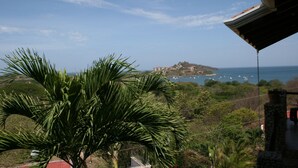 Blick auf die Küste mit einem Berg, Booten und blauem Himmel.
