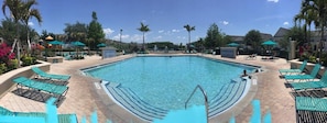 Une piscine avec des chaises longues et un poste de surveillance pour les sauveteurs.