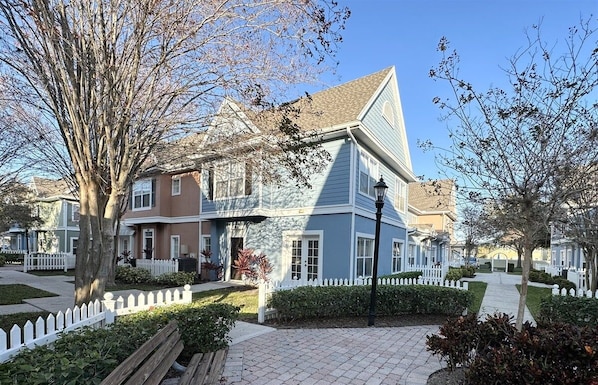 Un immeuble résidentiel doté d’un toit à pignon, d’un porche à l’avant et d’une clôture en piquets.