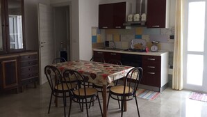 Eine kleine Küche mit Esstisch, Stühlen und Standardgeräten.