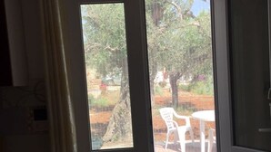 Ein Zimmer mit einer Schiebetür, die zu einem Außenbereich mit Tisch und Stühlen führt.