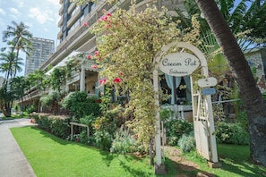 Experience a charming boutique hotel with a classic architectural style, lush greenery, and vibrant flowers.