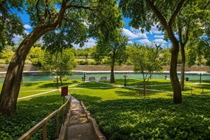 A park with a paved walkway leading to a viewing area overlooking a body of water.