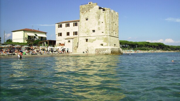 A coastal town with a prominent stone tower, beachside buildings, and clear blue waters. - Farmhouse Pescinone - Lavender, Etruscan Coast country and sea (Banditelle)