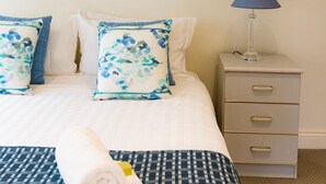 A hotel room with a bed, a nightstand, a lamp, and a framed picture on the wall. - Luxury Accessible Garden Retreat Near Beaches, Golf & Wineries (Point Lonsdale)