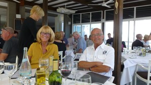 Een restaurant met gedekte tafels, wijnflessen en glazen.