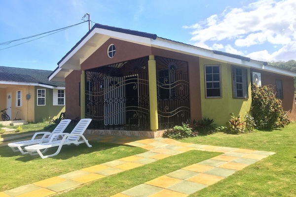 Veranda with table and chairs, plus open yard space with lounge chairs