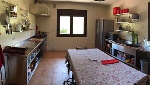 Une cuisine compacte comprenant une table à manger, un réfrigérateur et un four à micro-ondes.