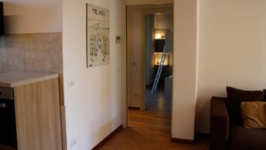 A kitchen with a tiled backsplash, a wooden countertop, and a wall-mounted poster labeled "MILANO".