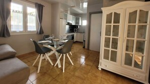 Un salon moderne avec une table à manger, un canapé et un meuble.