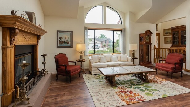 A spacious living room with a fireplace, a large window, a sofa, and a coffee table.