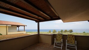 A balcony with two chairs, a tiled floor, and a view of the sea. - beautiful detached villa with private pool wi-fi (Briatico)