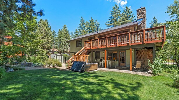 A two-story house with a wooden deck and a stone chimney. - Zephyr's Whisper! Lake Views, Hot Tub, King Beds (Zephyr Cove)