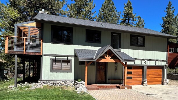 A modern two-story house with a balcony, a covered porch, and a garage. - Zephyr's Whisper! Lake Views, Hot Tub, King Beds (Zephyr Cove)