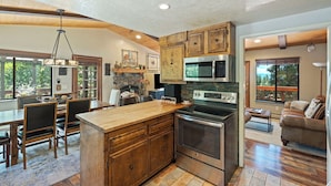 A modern kitchen with wooden cabinets, a large island, and stainless steel appliances. - Zephyr's Whisper! Lake Views, Hot Tub, King Beds (Zephyr Cove)