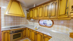 A kitchen with wooden cabinets, a stainless steel stove, and a patterned backsplash.