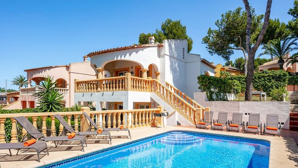 A poolside area with a clear blue pool, a two-story building with a balcony, and a staircase leading to the upper floor. - 0304 Monte Verde Naranja (Javea / Xàbia)
