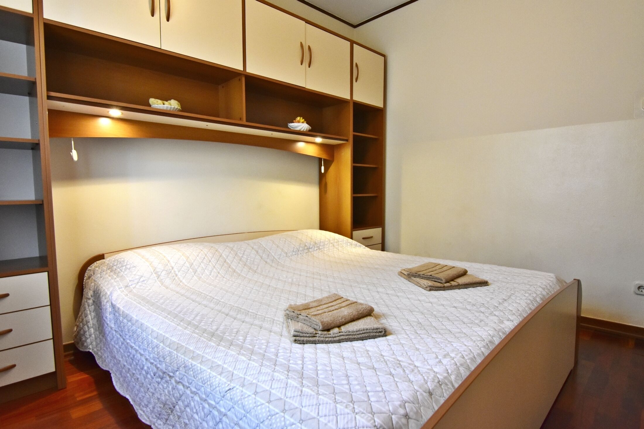 Une chambre à coucher comprenant un lit, une armoire intégrée et une table de chevet.