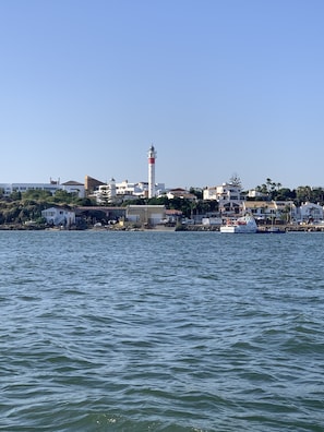 Une ville côtière dotée d’un phare imposant, d’eaux calmes et d’un mélange de bâtiments résidentiels et commerciaux.