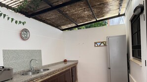 A kitchen with a tiled backsplash, a sink, a stove, and a refrigerator.