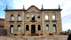 A historic building with a symmetrical facade, arched windows, and decorative stonework. - Villa De Rêve with Pool XXL (Fundao)