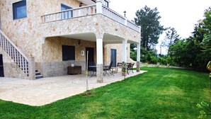 A stone building with a covered patio, outdoor seating, and a grassy lawn. - Villa De Rêve with Pool XXL (Fundao)