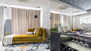 A modern bedroom with a yellow sofa bed, a large mirror, and a wine rack.
