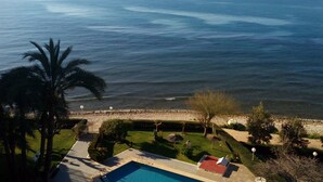 A coastal view with a swimming pool, palm trees, and a beach area. - PRIVATE ACCESS TO BEACH IN THE SAME URBANIZATION (El Campello)