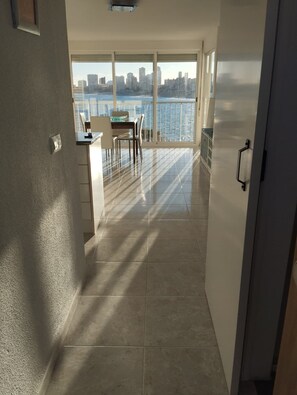 A spacious kitchen with a view of the city skyline and a dining area with a table and chairs. - PRIVATE ACCESS TO BEACH IN THE SAME URBANIZATION (El Campello)
