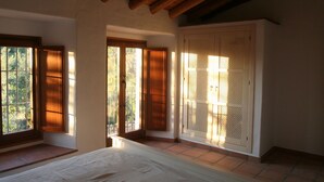 A room with a wooden ceiling, large windows, and a sliding door with a lattice design. - A comfortable country house situated in the Natural Park, Sierra de Grazalema. (Grazalema)