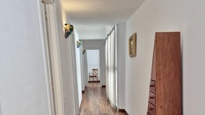 Ein Korridor mit Holzboden, weißen Wänden und einem Holzschrank.