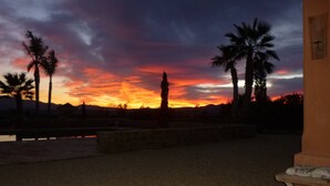 Vistes del capvespre amb palmeres i una muntanya lluny.