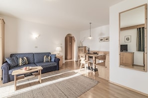 Relax in this stylish living room with a sofa, coffee table, and dining area.