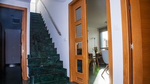 A staircase with dark marble steps leading to a second floor, wooden doors, and a dining area with a table and chairs. - Great penthouse in the center of Córdoba (Córdoba)