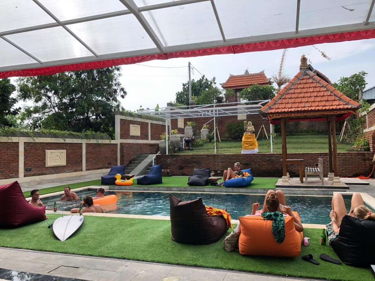 An outdoor pool area with lounge chairs and bean bags.