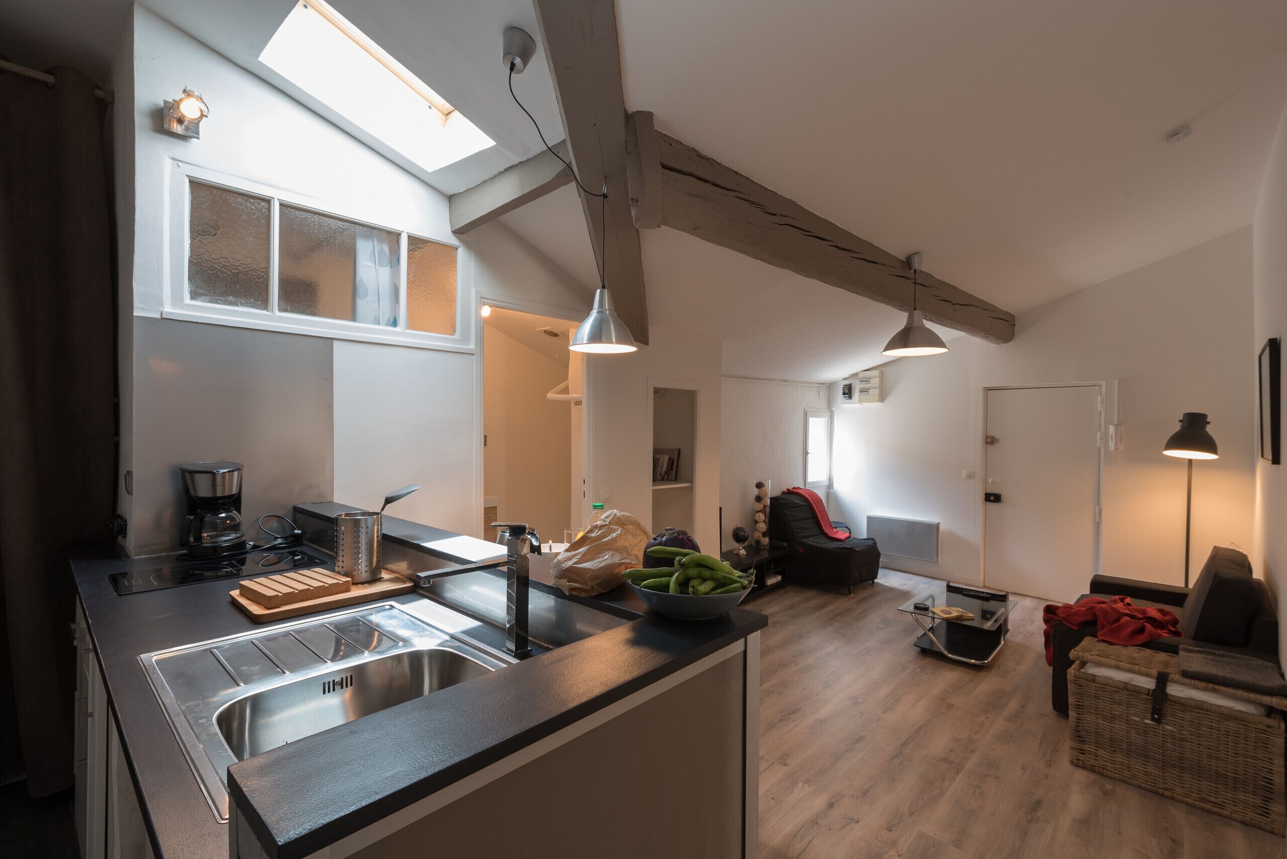 Cozinha moderna com uma ilha grande, eletrodomésticos embutidos e um espaço de refeições com sofá e mesa.
