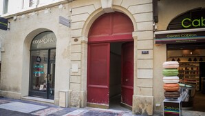 A building with a red door and a sign for 'Cosmopolitan'.