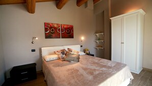 Een slaapkamer met een bed, een kledingkast en twee wandlampen.
