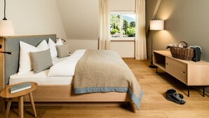 Una camera da letto con un letto, un comodino, una lampada e vista sul verde.