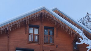 A wooden chalet with a balcony and snow-covered roof. - Authentic, cosy chalet for an ideal family holiday (Briançon)