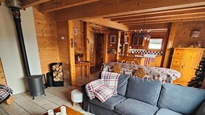 A cozy living room with a sofa, a wooden coffee table, and a fireplace. - Authentic, cosy chalet for an ideal family holiday (Briançon)