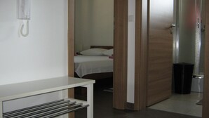 A hotel room with a bed, a bedside table, and a telephone.