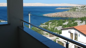 A balcony with a view of the sea and rocky coastline.
