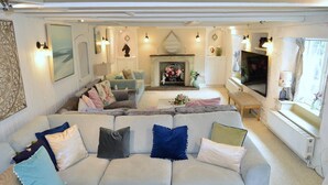 A cozy living room with a sectional sofa, a fireplace, and a television.