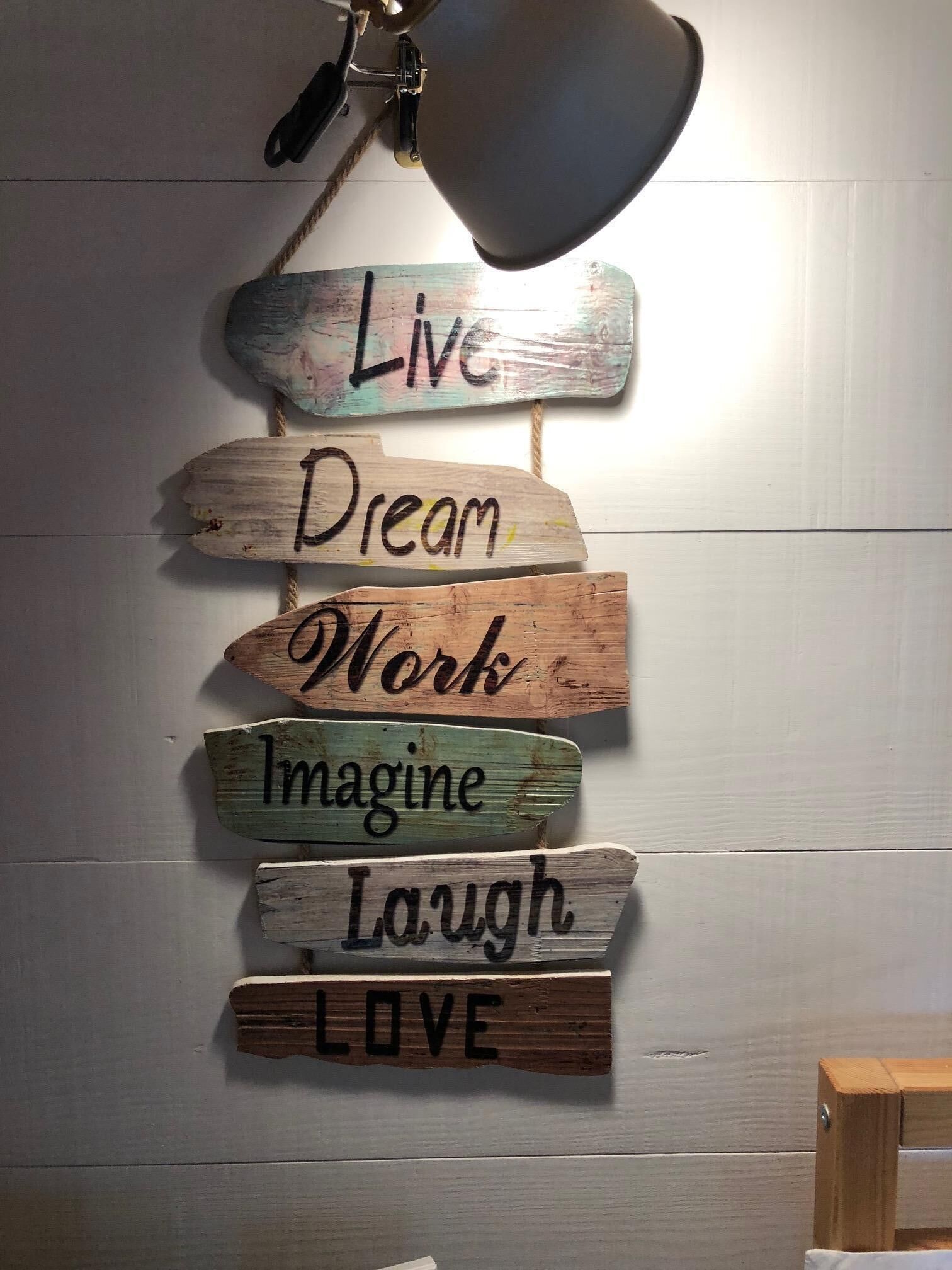 Un mur orné d’une enseigne en bois sur laquelle figurent des phrases inspirantes.